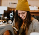 woman in mustard color beanie smiling
